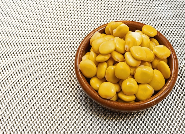 An clay bowl with a lupine a typical Spanish bar snack on an insulated metal base