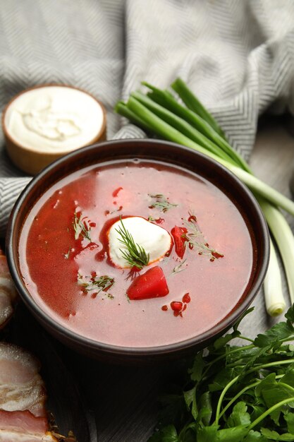 Clay bowl with Ukrainian borsch served on table