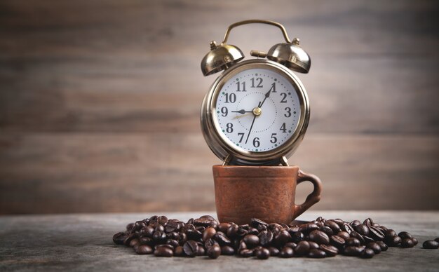 Clay coffee cup and alarm clock. Coffee time