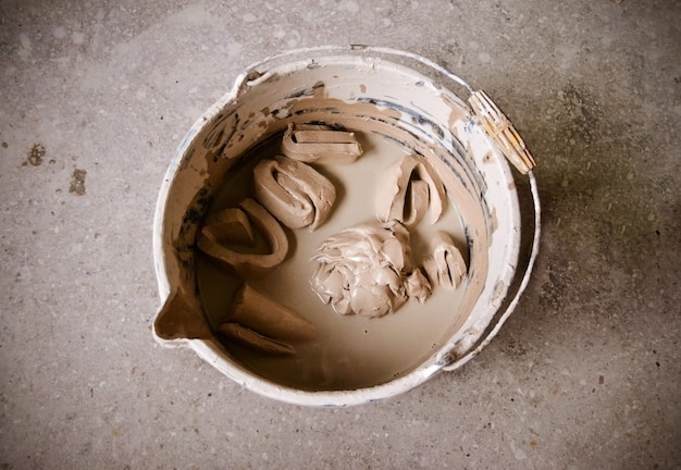 Clay pieces soak in water in a bucket