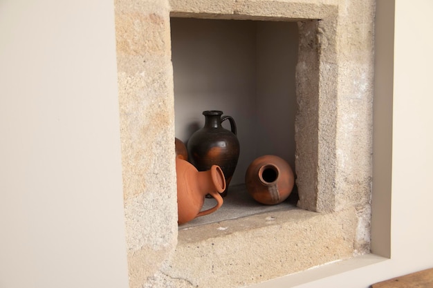 Clay pots, stuck in a hole in the wall. Decoration concept.