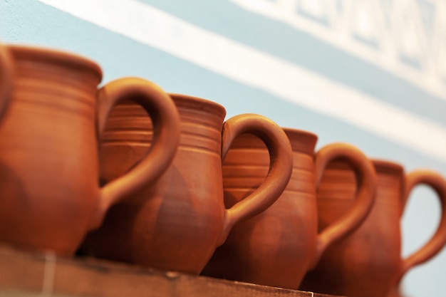 Clay pots on a wooden shelf close up