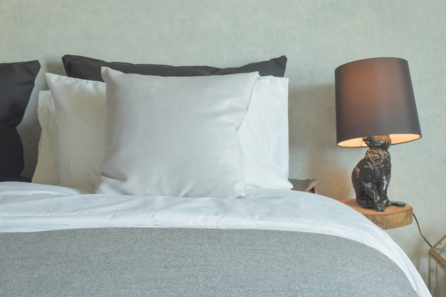 Clean bed in hotel guestroom with brown reading lamp