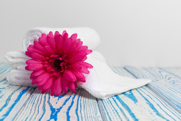 Clean soft towels with flower on wooden table