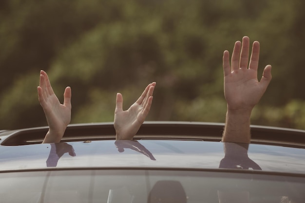 Clean transportation Sustainable or green transport Hands gesturing in open car hatch Travelling by car Enjoying road trip Automobile transport Eco friendly and sustainable travel