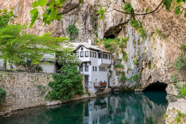 A clean underground river emerges from a cave near an Islamic mosque