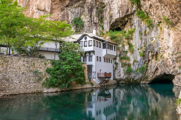 A clean underground river emerges from a cave near an Islamic mosque