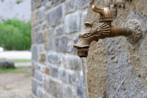 Clean water running from artesian source vintage tap outside Pyrenees national reserve park Spain