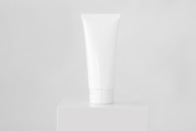 Clean white tube of moisturizer on a pedestal