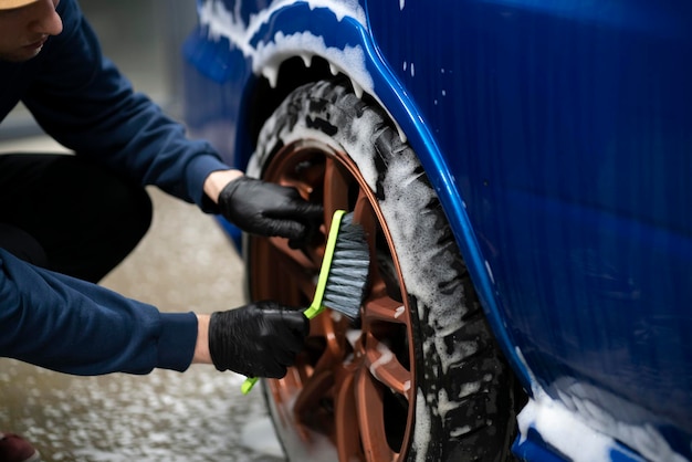 Cleaning car wheel with a brush workshop auto service