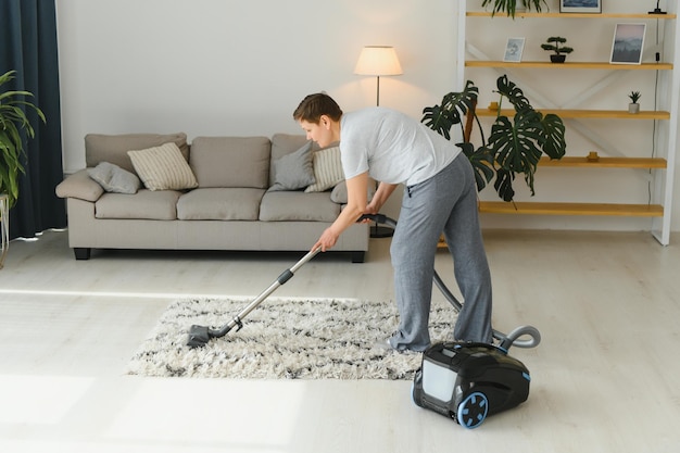 Cleaning concept woman cleaning carpet with vacuum cleaner