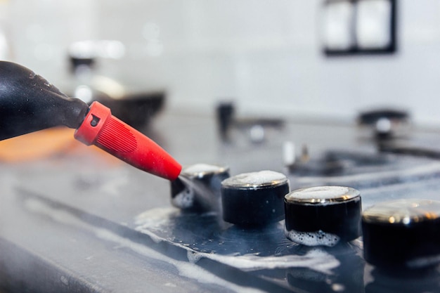 cleaning the gas stove with a steam cleaner cleaning the kitchen by a cleaning company