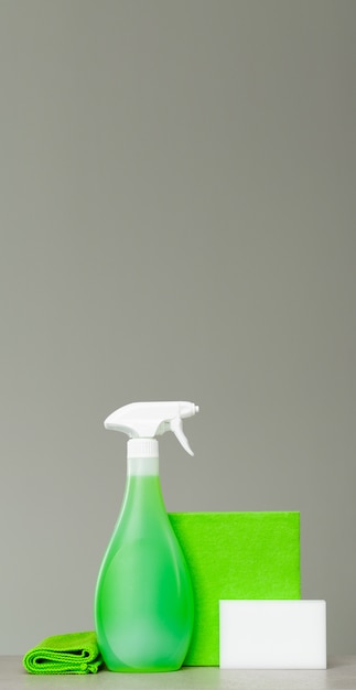 Cleaning green spray bottle with plastic dispenser, sponge and cloth for dust.