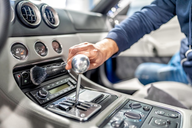 Cleaning the interior of a luxury car with a brush