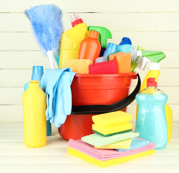 Cleaning items in bucket on white wooden background