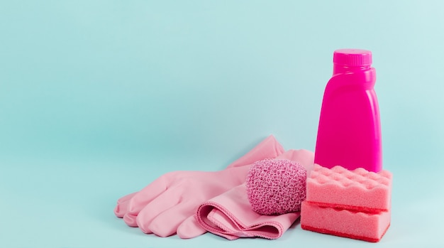 Cleaning pink supplies collection on blue background Housework concept