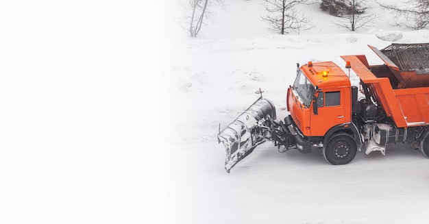 Cleaning roads in the city from snow in winter. A big car is driving and cleaning the snow