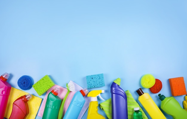 Cleaning supplies on blue background. Top view