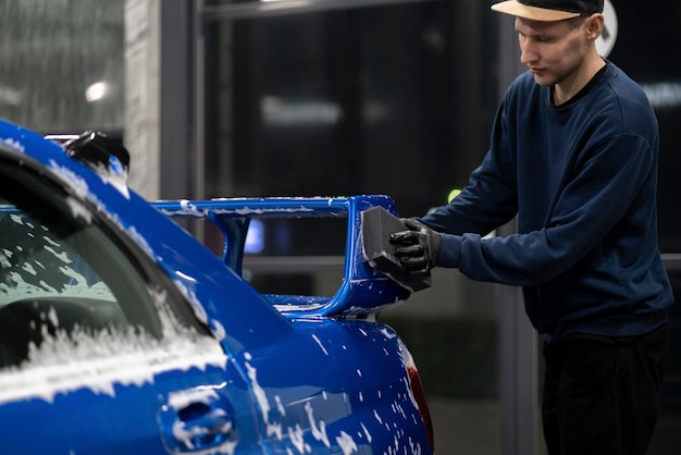 Cleaning and washing a car wiping the body with foam and sponge