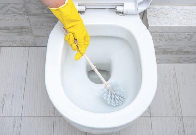 Cleaning wc Housekeeper cleaning man at toilet Brush up Toilet for cleanliness and hygiene cleaning toilet bowl Cleaning service concept