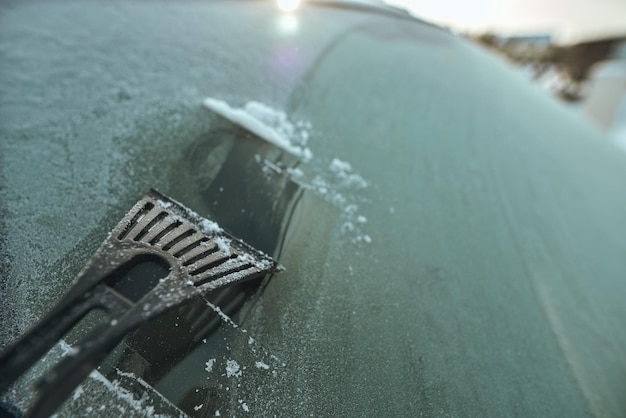 Cleaning the windshield from ice with a plastic ice scraper