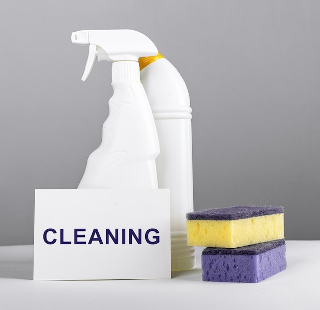 Cleaning word concept Chemical detergents in plastic bottles and washing sponges for home cleanup