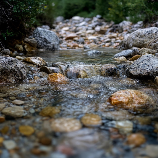 Photo clear stream flowing over smooth rocks