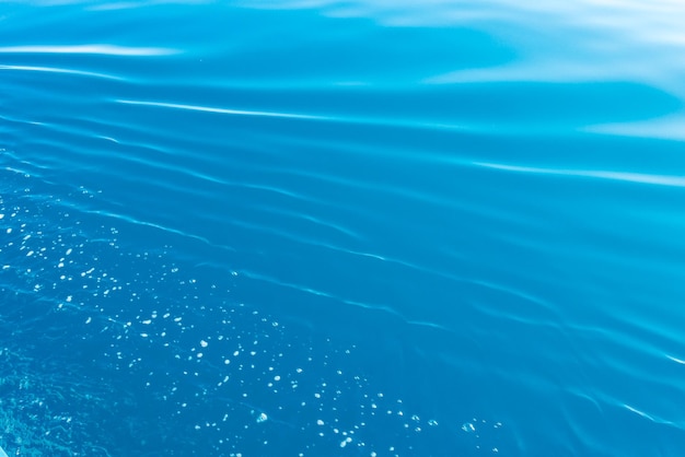 Clear water texture in blue and orange Background of the ocean and the sea backlit by the sun Natural water