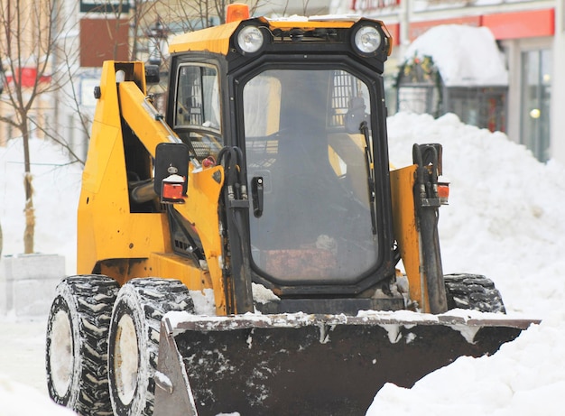 Clearing snow from the road with bulldozer in the city, urban landscape