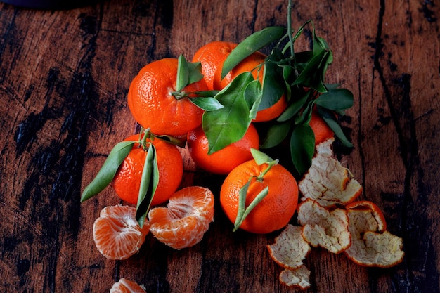 Clementines with leaves on an old wooden table