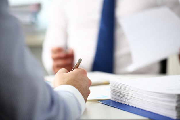 Clerk man at office workplace with silver pen in arms