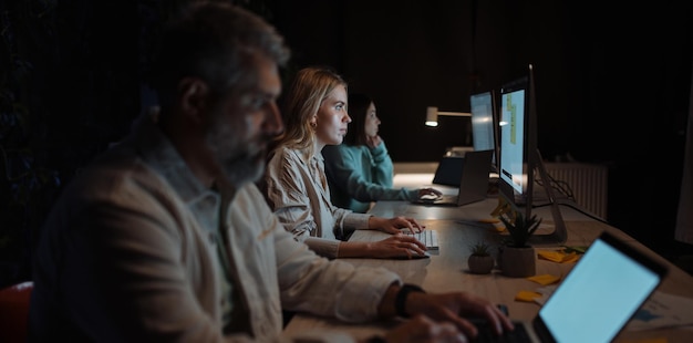 Clever and hard working team girl wearing stylish clothing using pc computer in cozy evening office