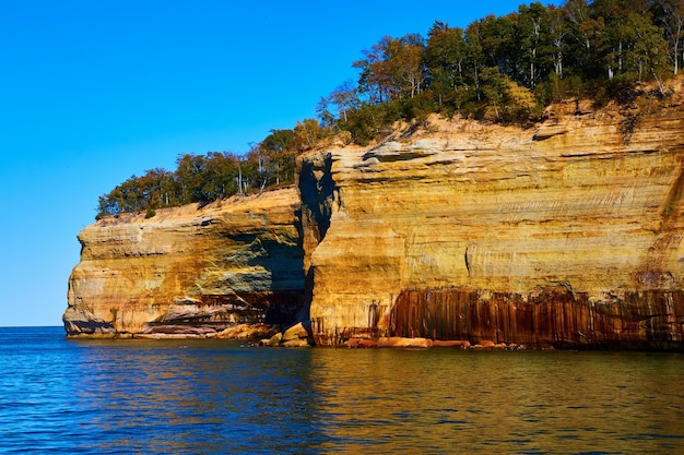 Cliff wall of pictured rocks at Michigan National Park with forest atop large cliffs