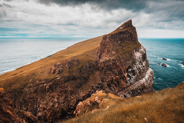 Cliffs and the village on the island of Mykines, Faroe.