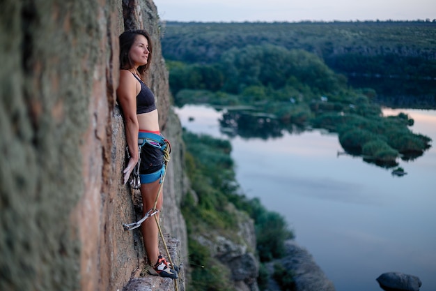 Photo climber overcomes challenging climbing route. a girl climbs a rock.