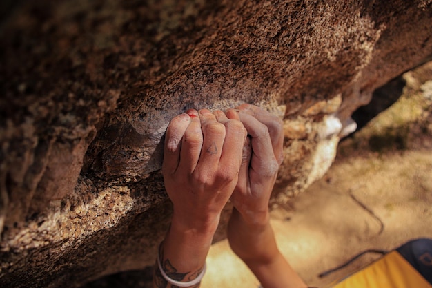 A climber person holding a rock with his hand