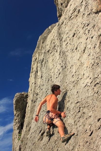 Climber on a rock on the sunset background