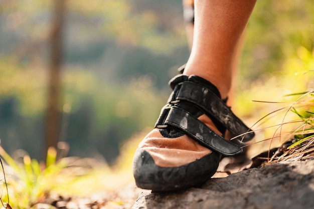 Climber wearing in climbing equipment Practicing rockclimbing on a rock mountain wall Climbing sports and bouldering concept Climber climbs on a rocky wall Climbing shoes