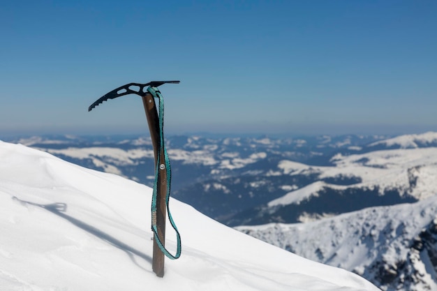 Climber39s ice ax stuck on a snowy slope winter mountain climbing