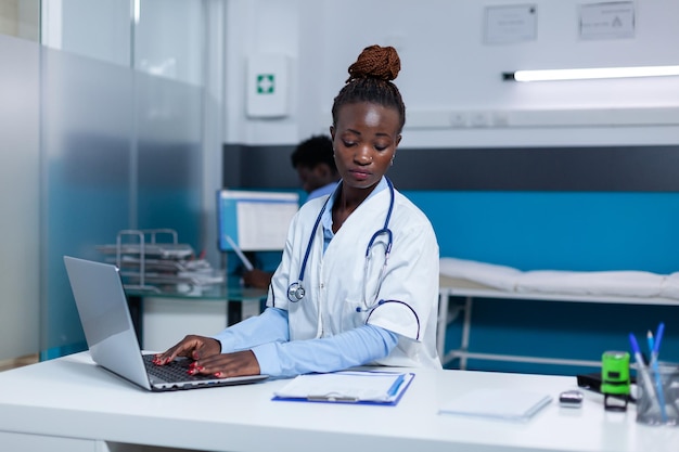 Clinic doctor specialist using computer to verify medication records and consultation appointments. Hospital physician expert searching medical information and disease reports in clinic database