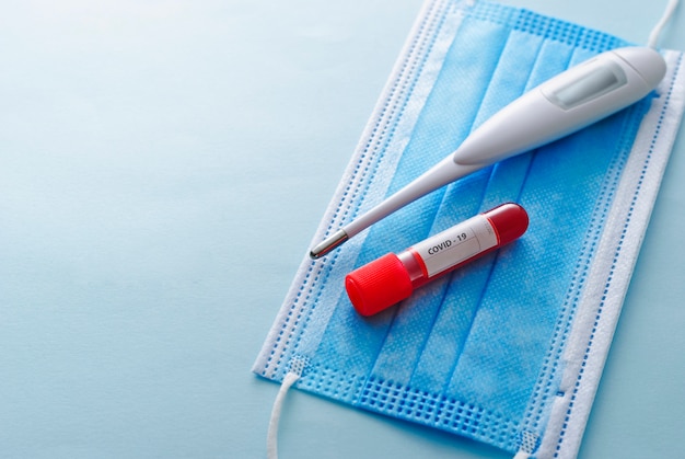 Clinical thermometer, tube of blood and face mask