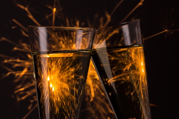 Clink glasses with fireworks background on new year's eve