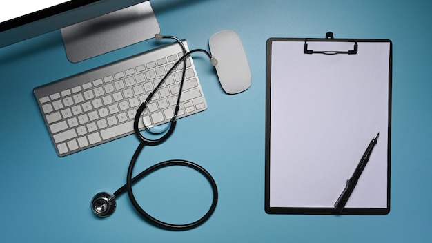 Clipboard stethoscope and computer on blue background Healthcare and medical concept