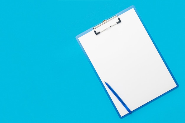 Clipboard with a blank sheet and a pen on a light blue background. Concept questionnaire, form, contract. Banner. Flat lay, top view.