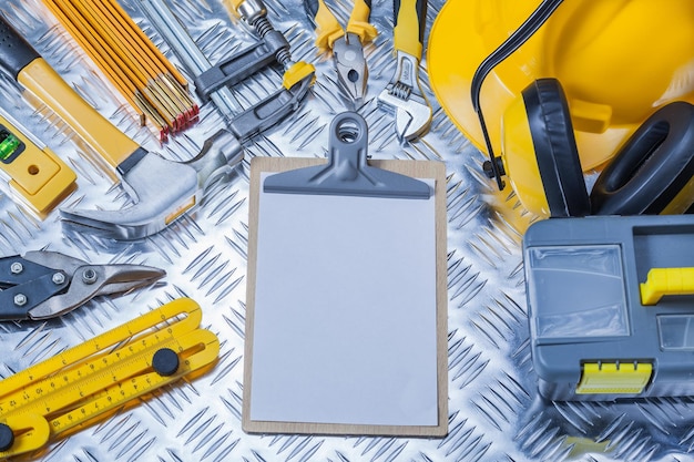 Photo clipboard with white sheet of paper and set construction tools