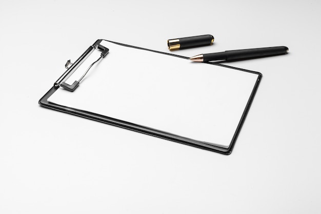 Clipboard with white sheet and pen isolated on white. 