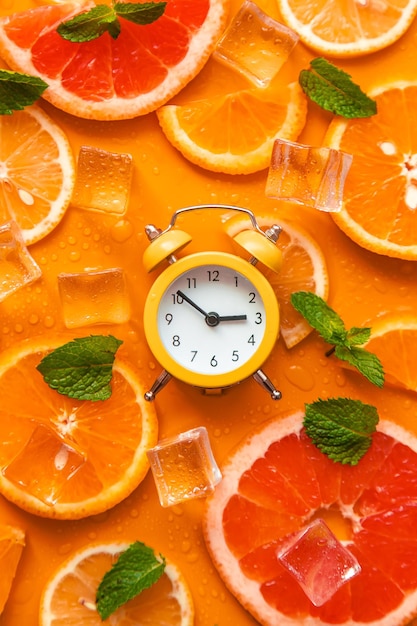 Clock and citruses summer time concept Selective focus