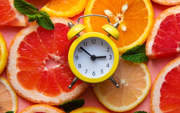 Clock and citruses summer time concept Selective focus