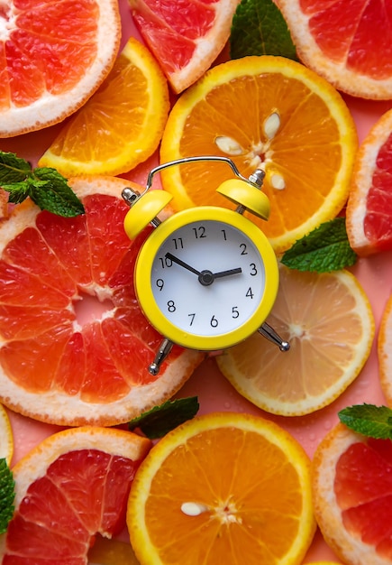 Clock and citruses summer time concept Selective focus