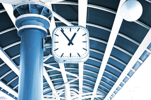 A clock hangs from a blue column with the number 1 on it.